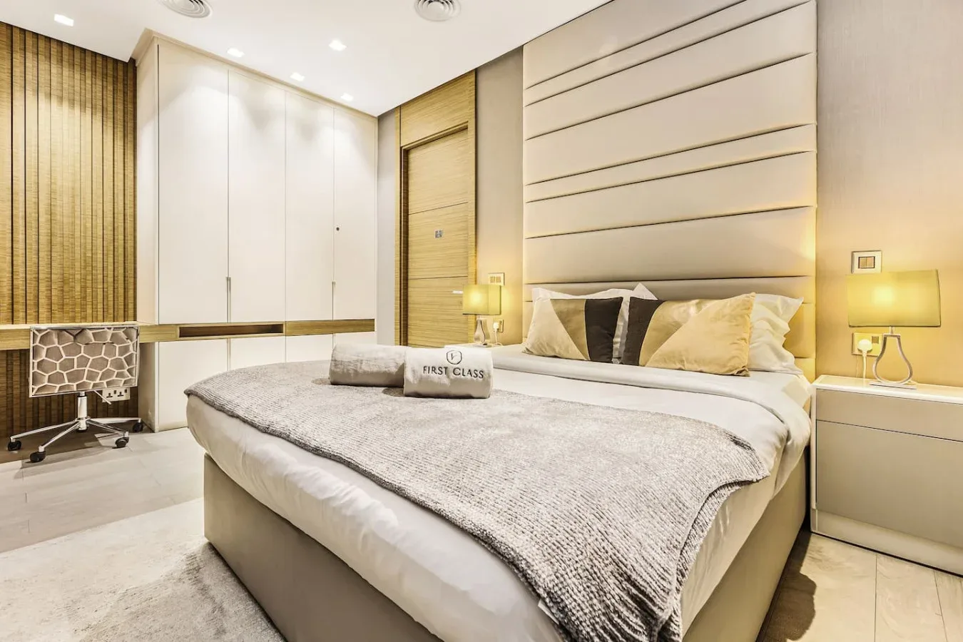 Un dormitorio luminoso con una cama grande, lámparas de noche y armarios empotrados.