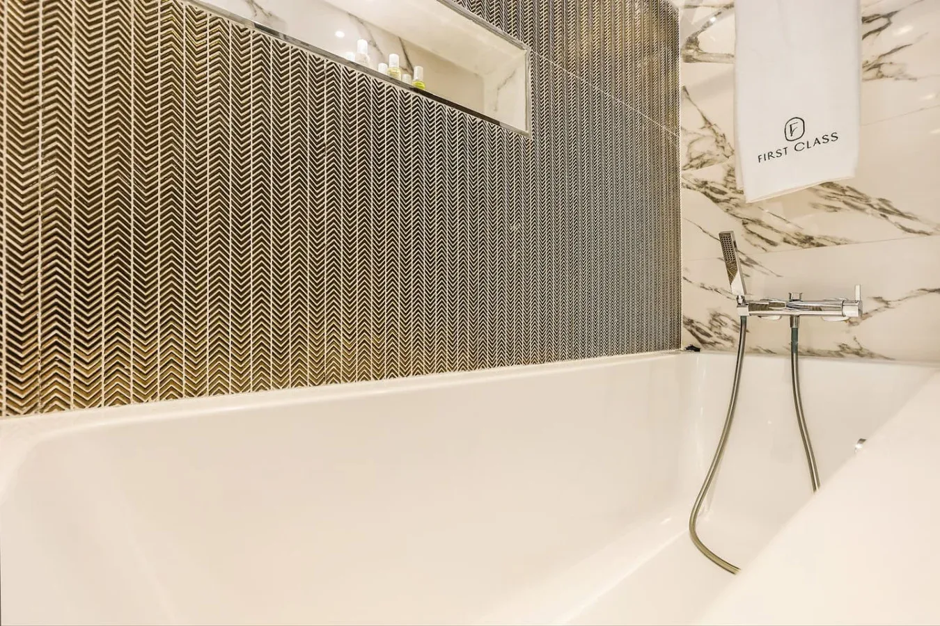 Un baño con bañera y accesorios de ducha montados en la pared.