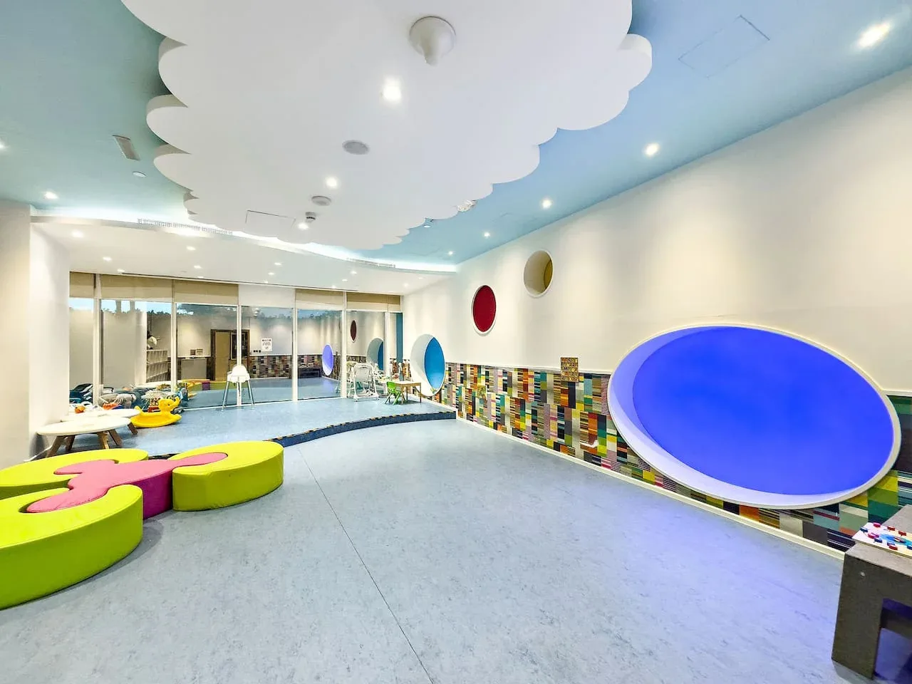 Una sala de juegos interior colorida, con adornos llamativos en las paredes y asientos bajos.