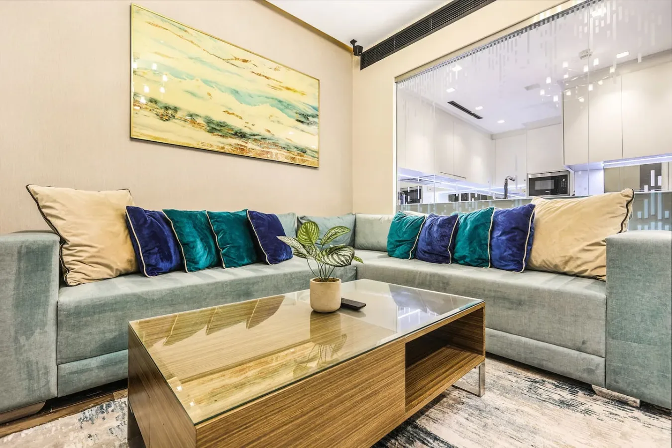 Una sala de estar con asientos en forma de L y una mesa de centro con tapa de vidrio.