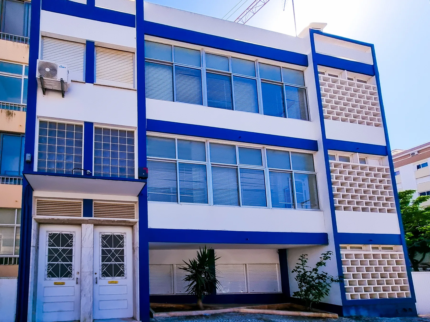 A blue-and-white building exterior with rows of windows.