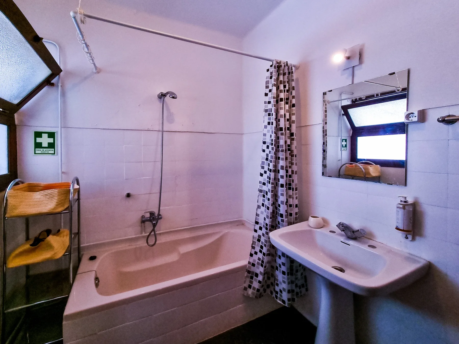 A bathroom with a bathtub, shower, and sink.