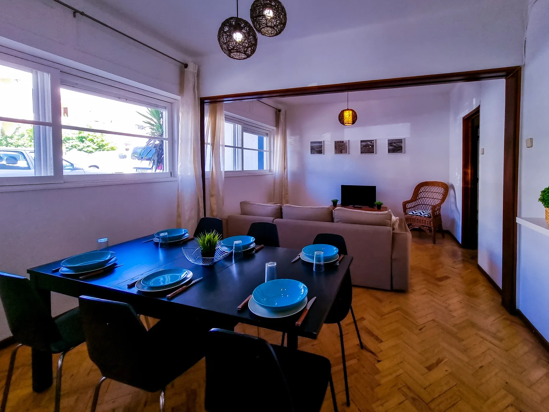 Sala de estar y comedor con sofá, televisor y mesa de comedor.