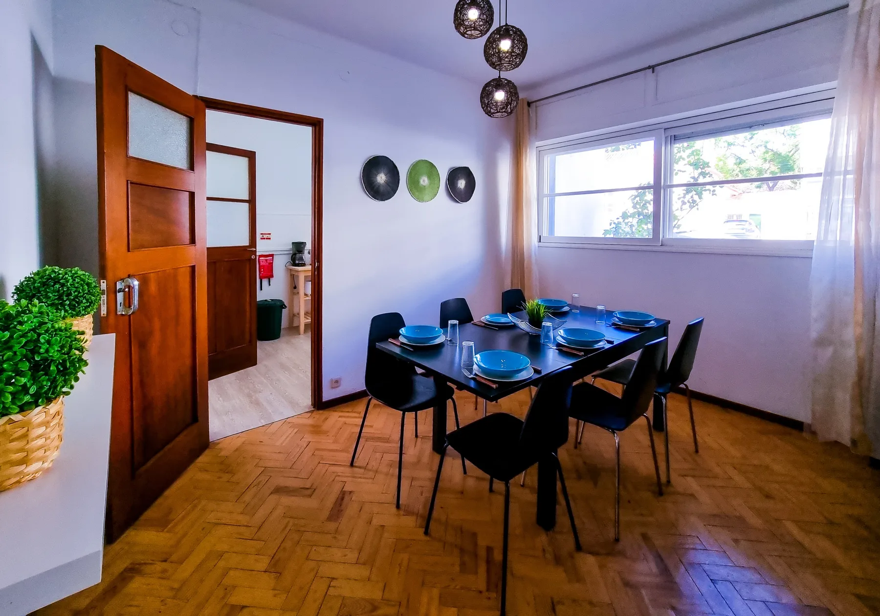 A dining area with a set table beside a large window.