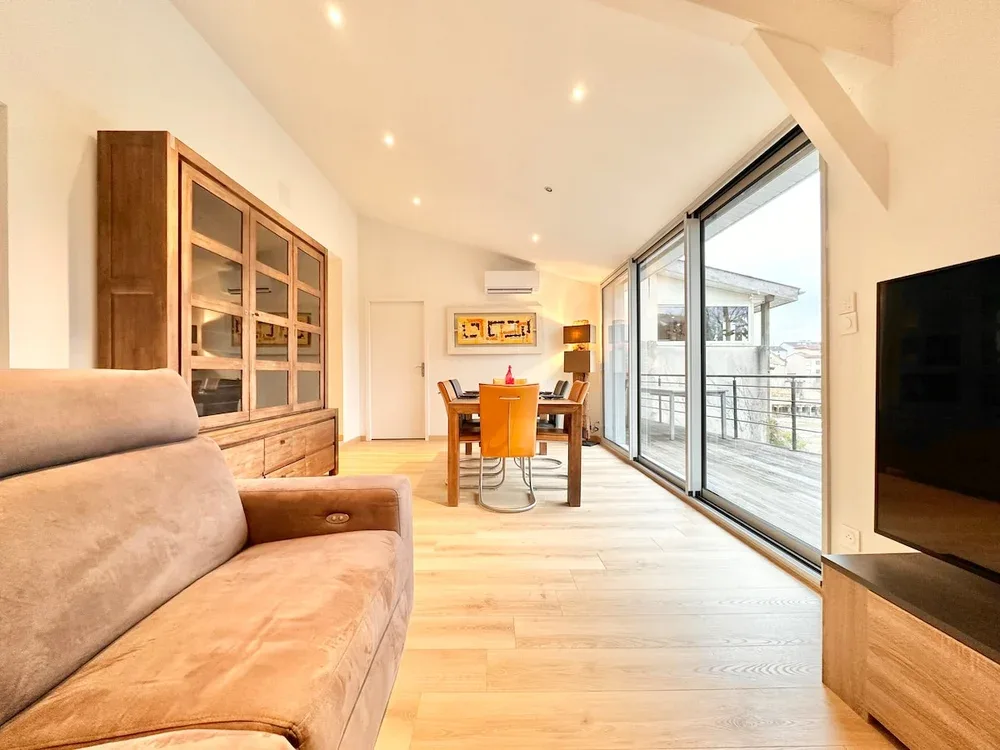 A bright living and dining area with seating and large glass doors.