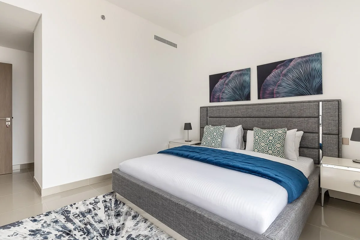 Un dormitorio con una cama grande, cuadros decorativos y una alfombra.