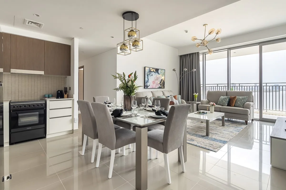 An open-plan living and dining area with a kitchen and large windows.