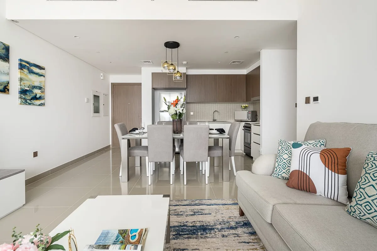 Una sala-comedor de planta abierta con cocina y un sofá de color claro.