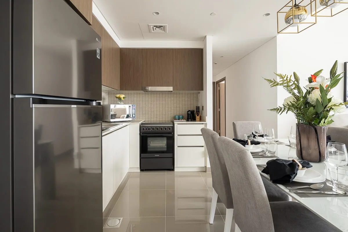 Una cocina moderna se abre a un comedor con la mesa puesta.