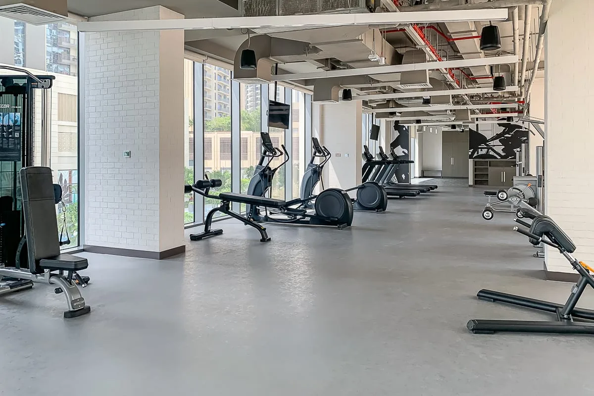 Un gimnasio amplio con máquinas de ejercicio y equipo de entrenamiento con pesas.