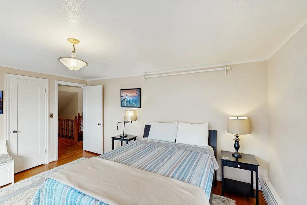 A bedroom with a neatly made bed and matching bedside tables.