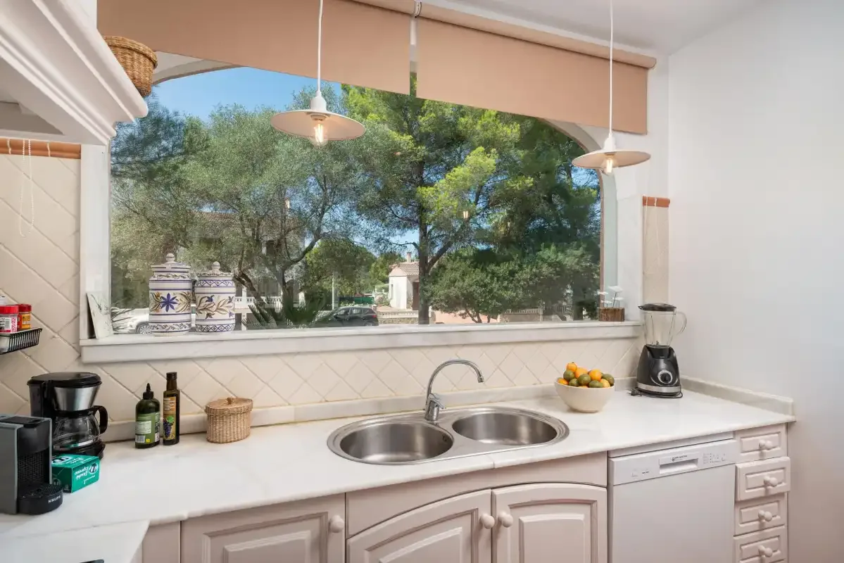 A kitchen with a double-basin sink beneath a large window.