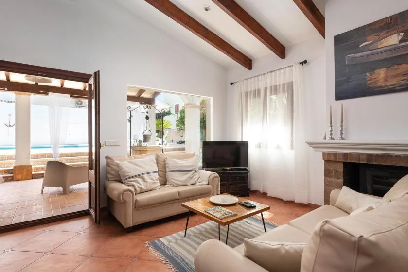 A bright living room with seating, a coffee table, and a fireplace.