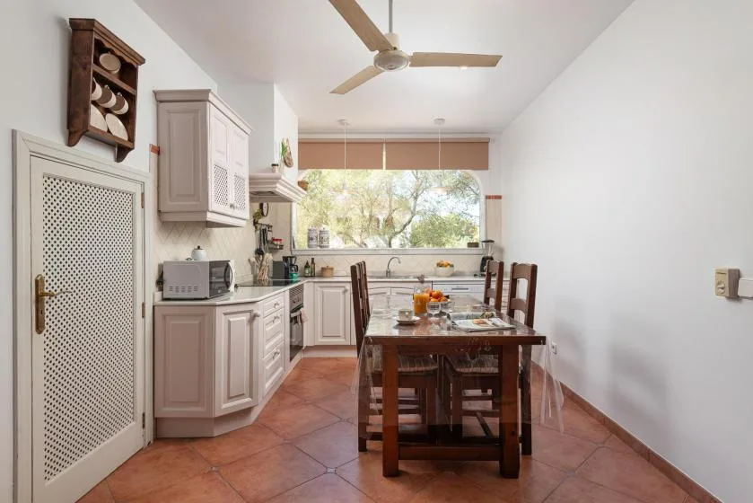 A dining area with a wooden table beside the kitchen.