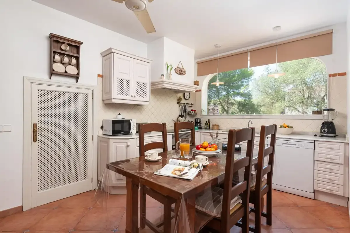 A dining area with a wooden table beside a kitchen.