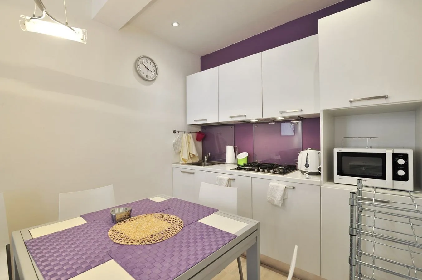 Una cocina compacta con zona de comedor y una mesa en primer plano.