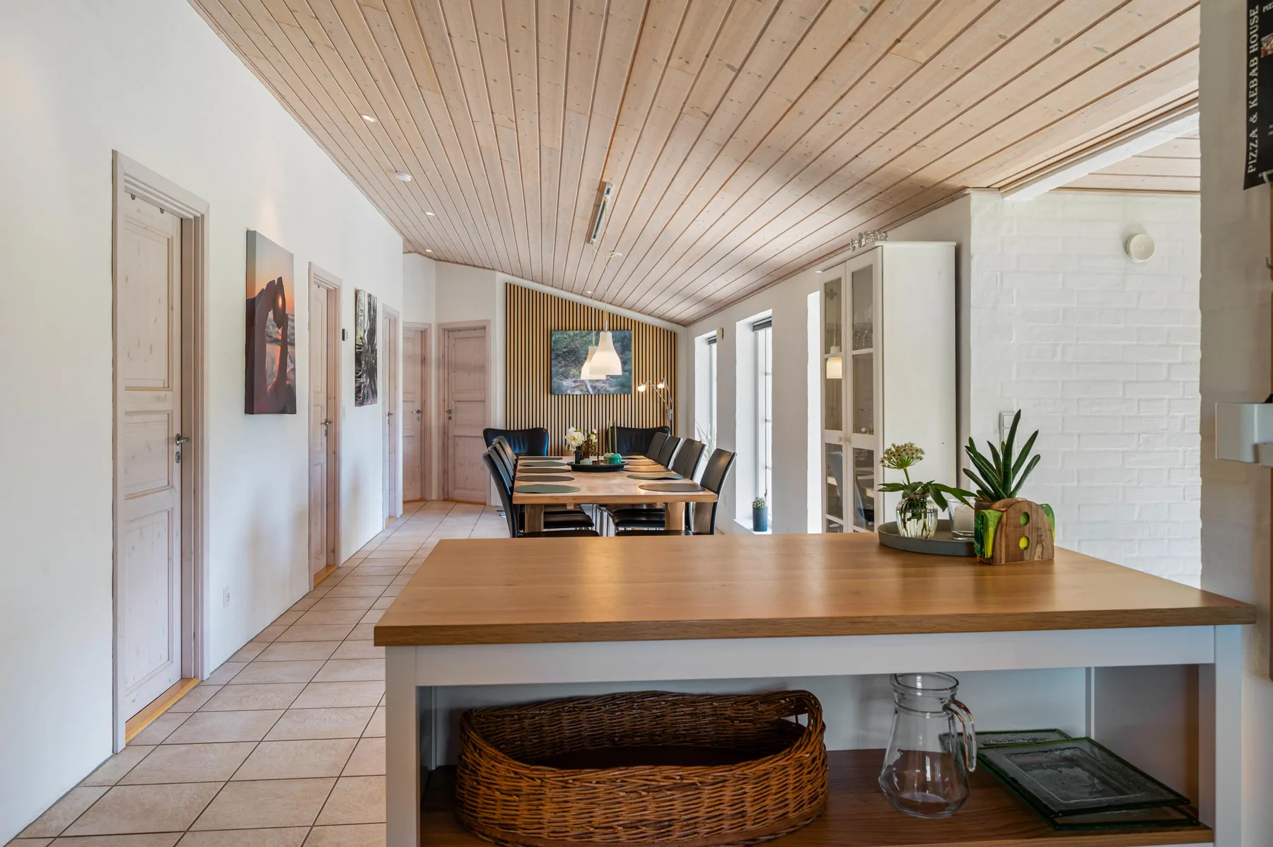 Un comedor luminoso con una mesa larga y una encimera de madera en primer plano.