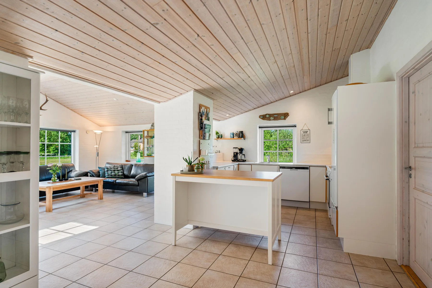 Una cocina abierta al salón, con una barra central y zona de estar.