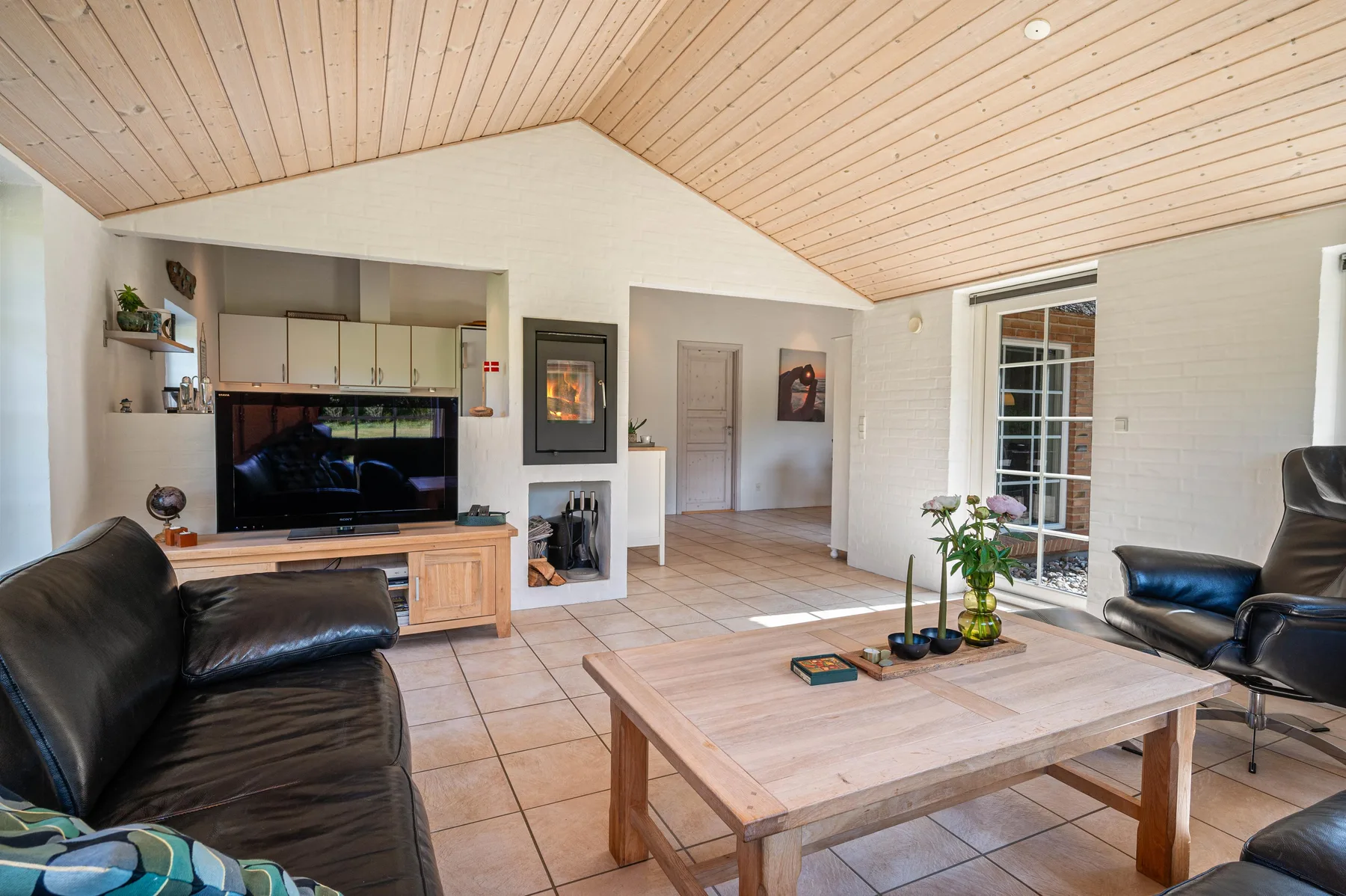 Una sala de estar con asientos, un televisor y una mesa de centro de madera.