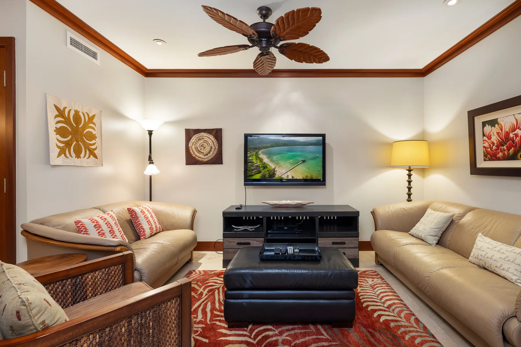 A living room with seating arranged around a coffee table and television.