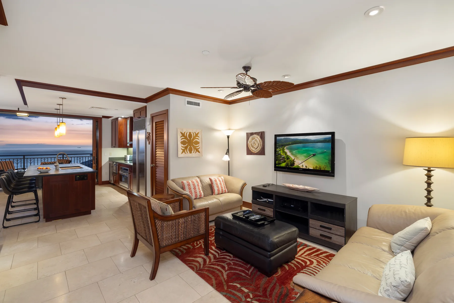 A living room with seating, a television, and a dining area overlooking the water.