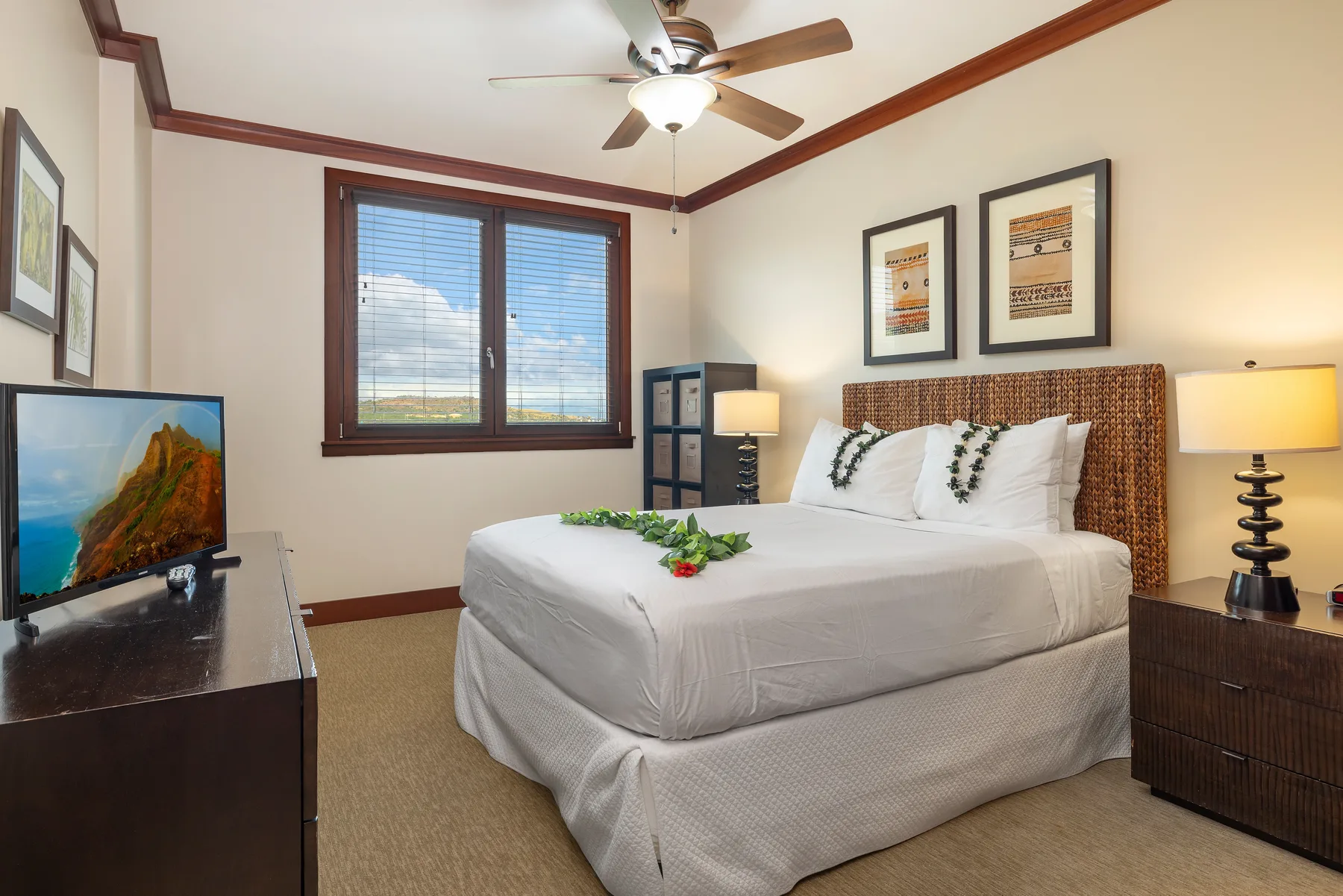 A bedroom with a neatly made bed, window, and ceiling fan.