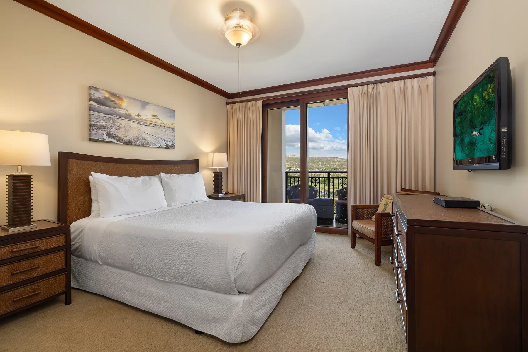 A bedroom with a bed, bedside tables, and sliding doors opening onto a balcony.