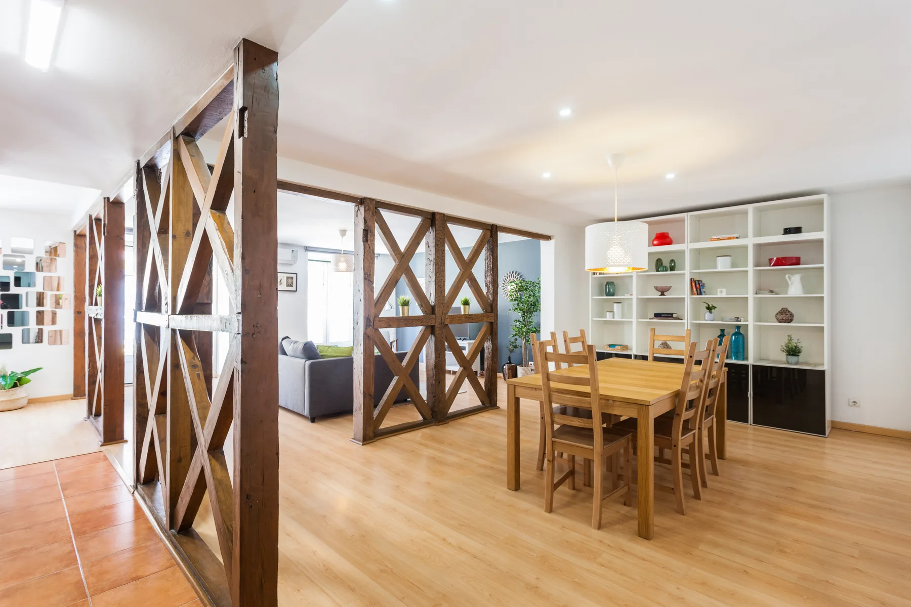 Una zona de comedor abierta con una mesa de madera y estanterías.