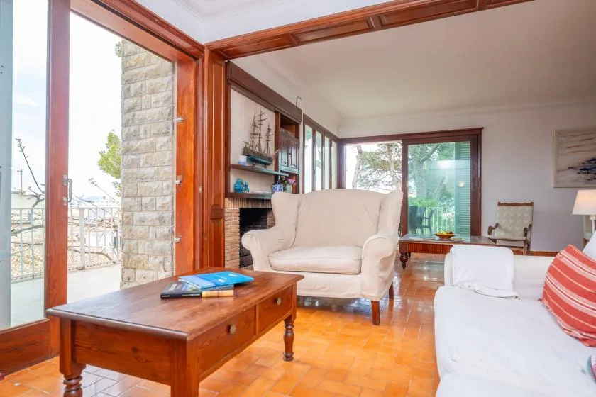 A bright living room with seating, a wooden coffee table, and large glass doors.
