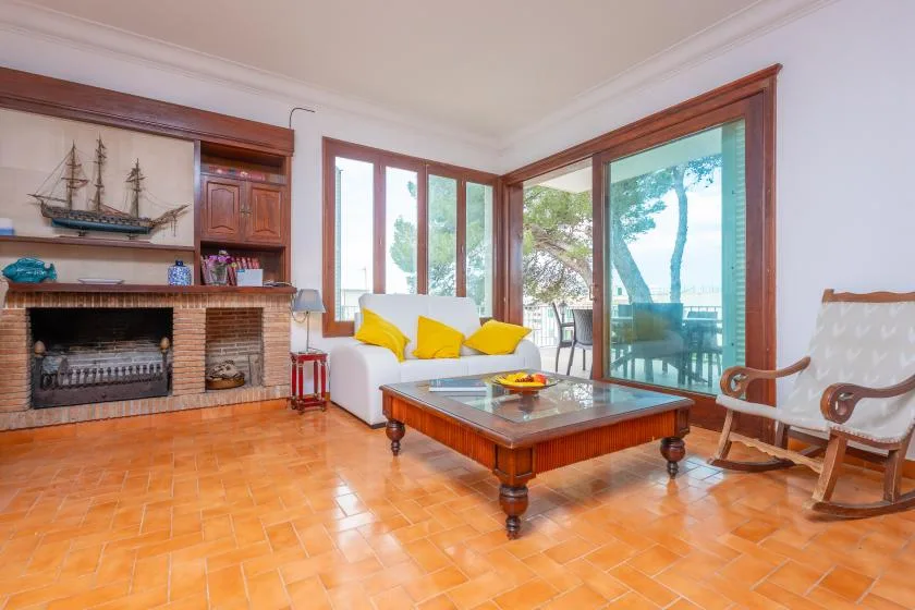 A bright living room with seating, a coffee table, and large windows.