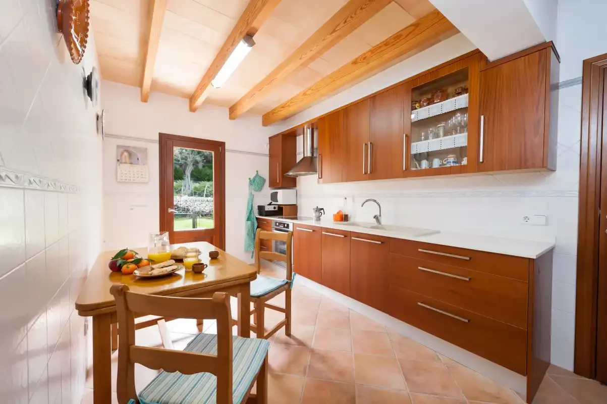 A bright kitchen and dining area with wooden cabinetry and a table.