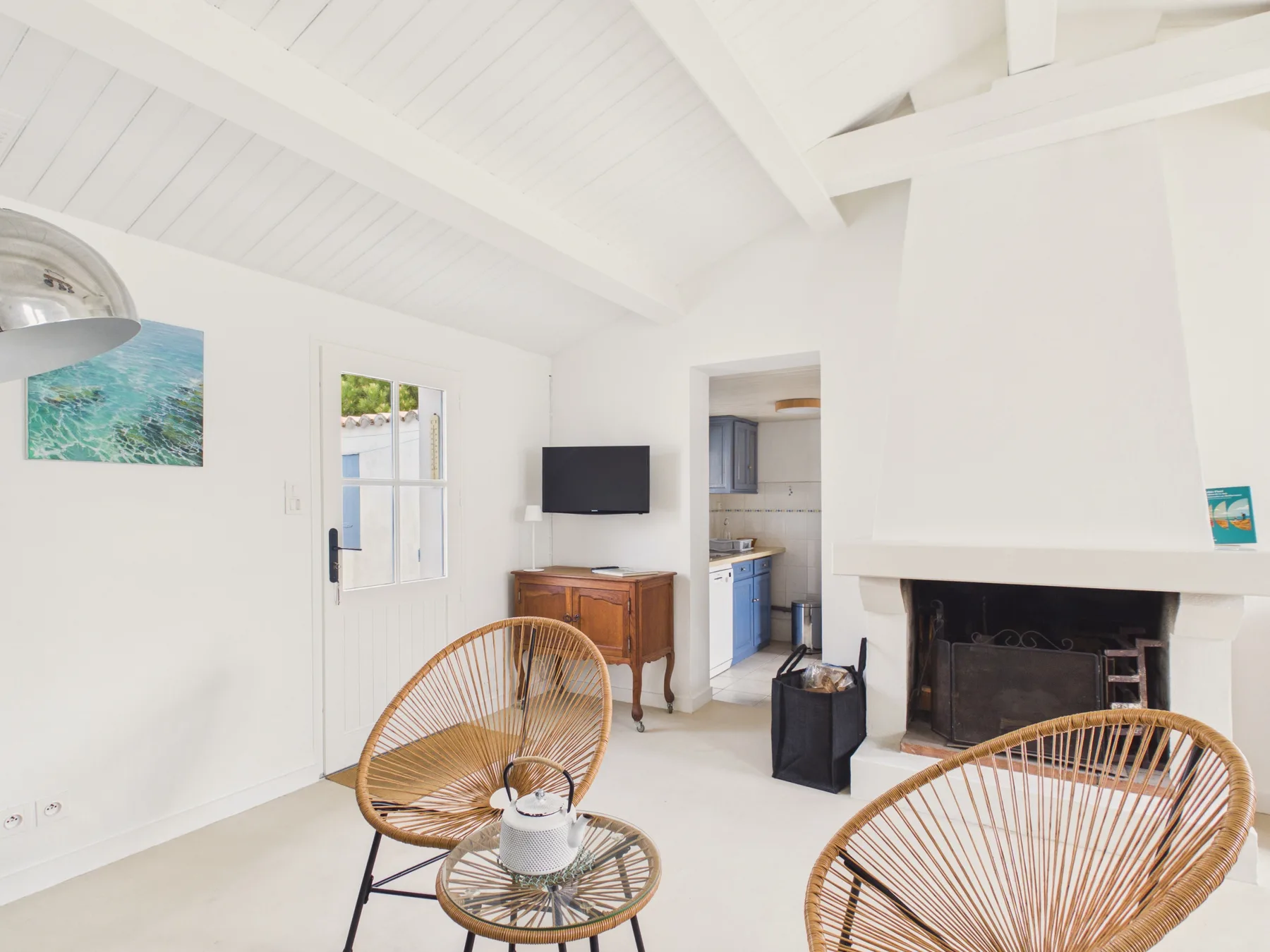 Bright living room with woven seating and a fireplace.