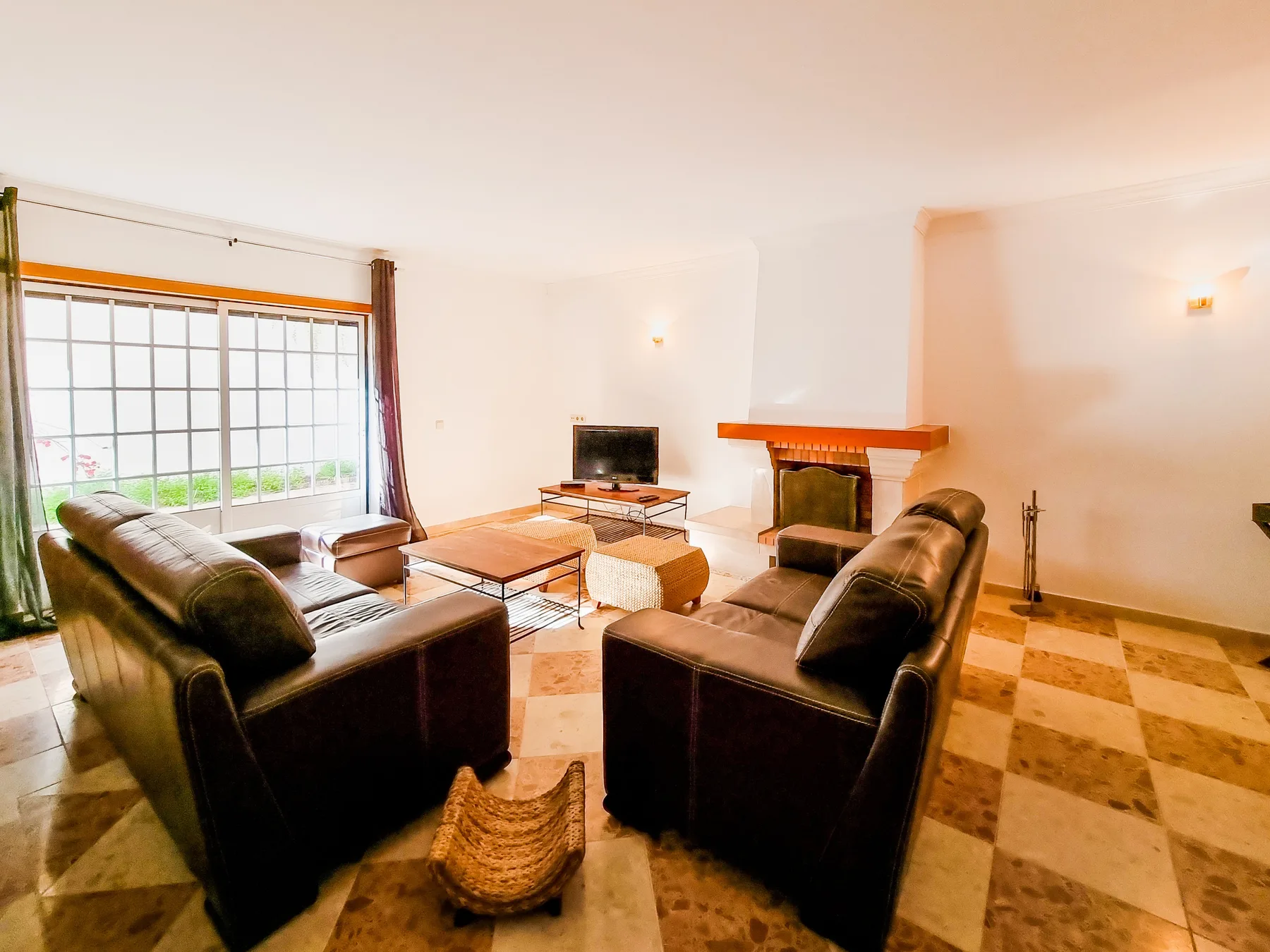 Una sala de estar con asientos alrededor de una mesa de centro y una chimenea.