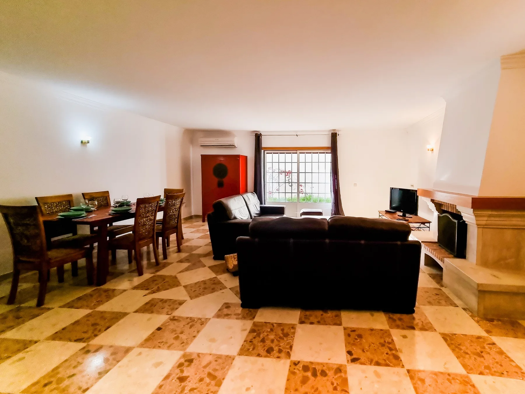 Sala de estar y comedor con asientos, una mesa de comedor y una chimenea.