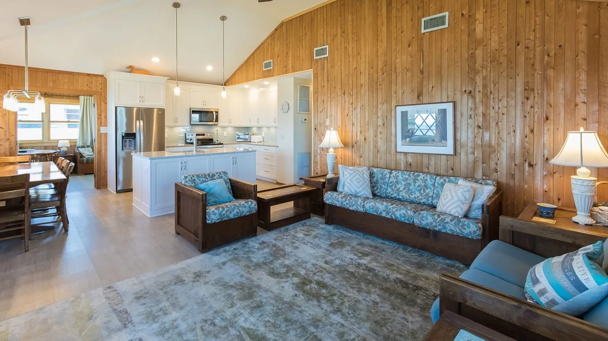 A living room with patterned seating beside an open kitchen.