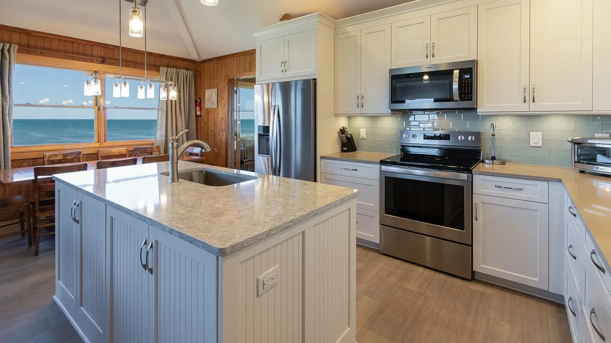 A bright kitchen with a central island and windows overlooking the water.