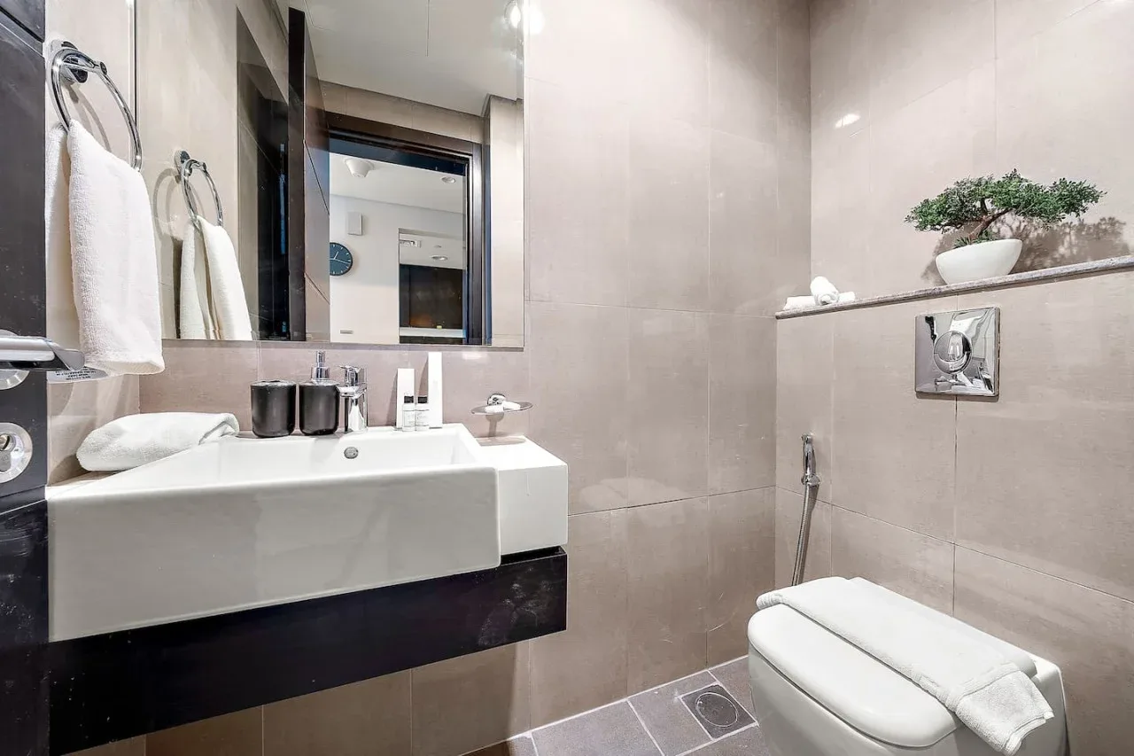 A modern bathroom with a wall-mounted sink and toilet.