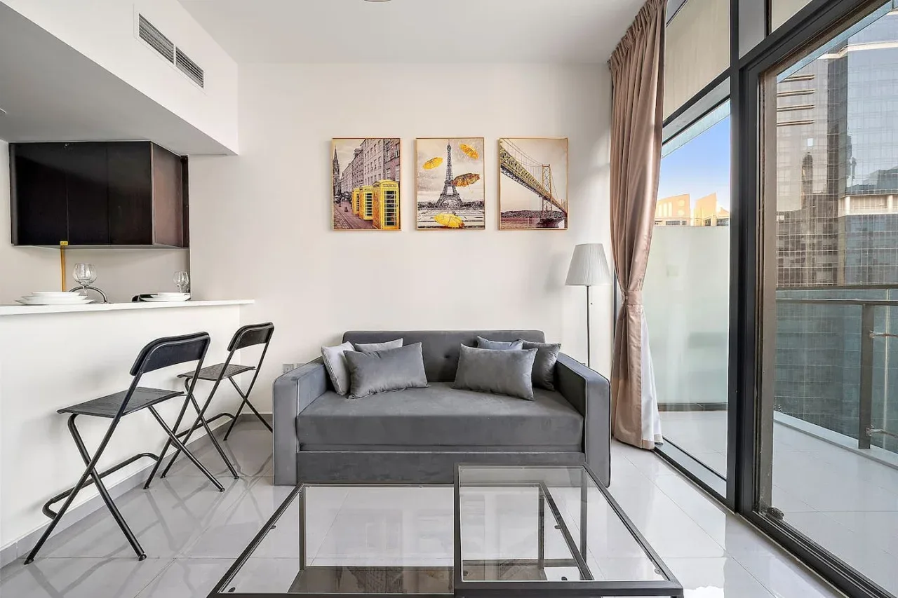 A bright living area with a gray sofa beside a floor-to-ceiling window.