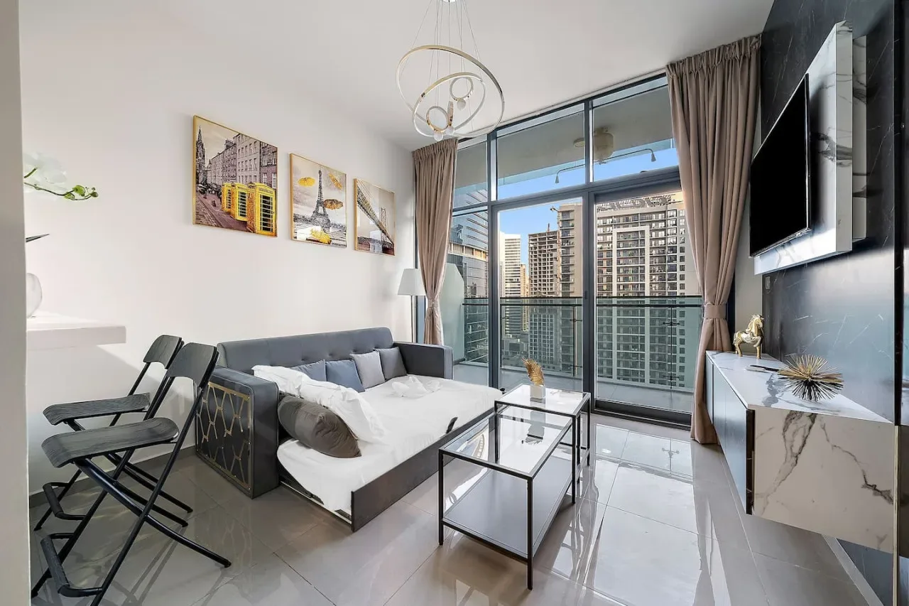 A modern living room with a sectional seating area and floor-to-ceiling windows.