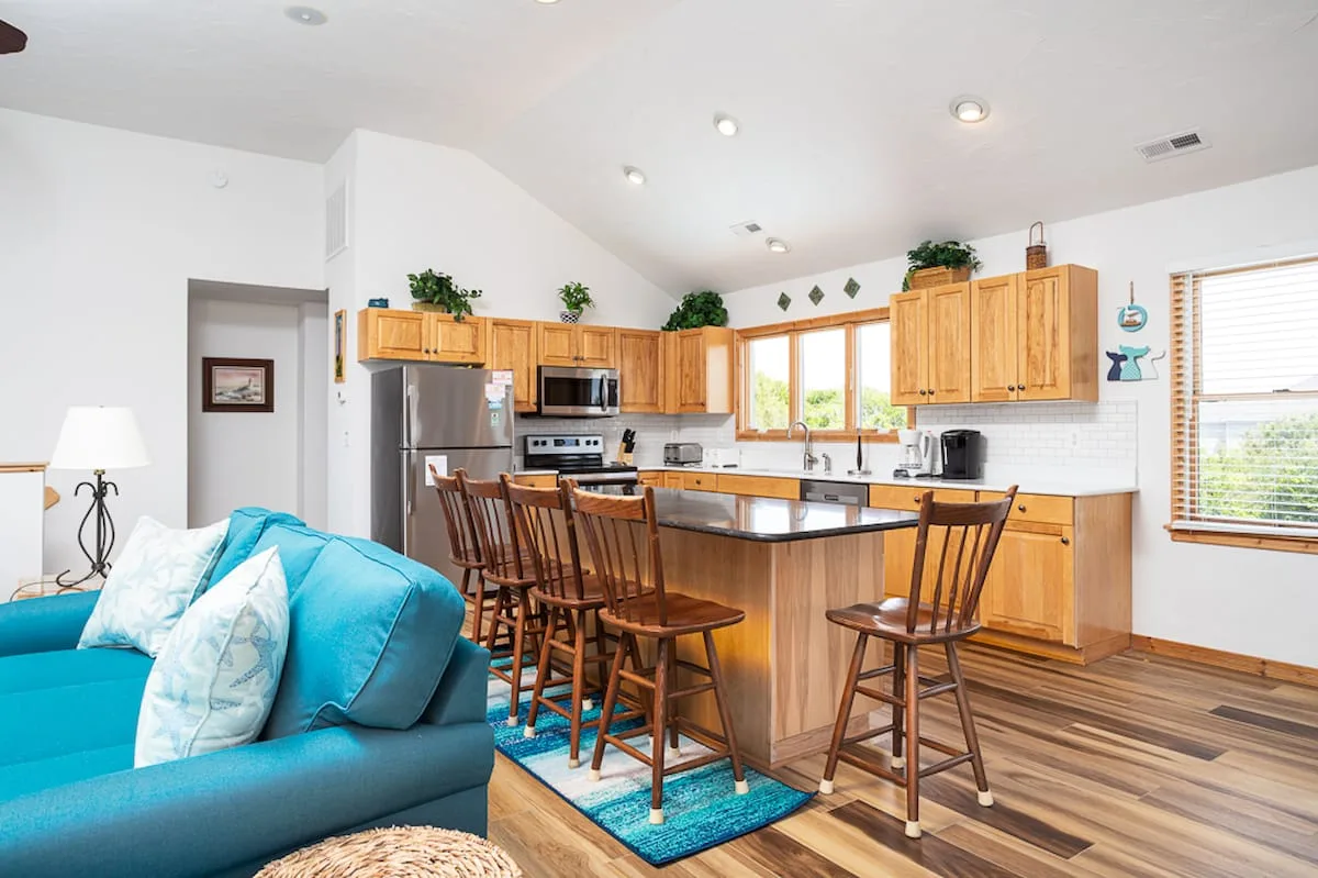 An open kitchen and living area with a wooden island and blue seating.