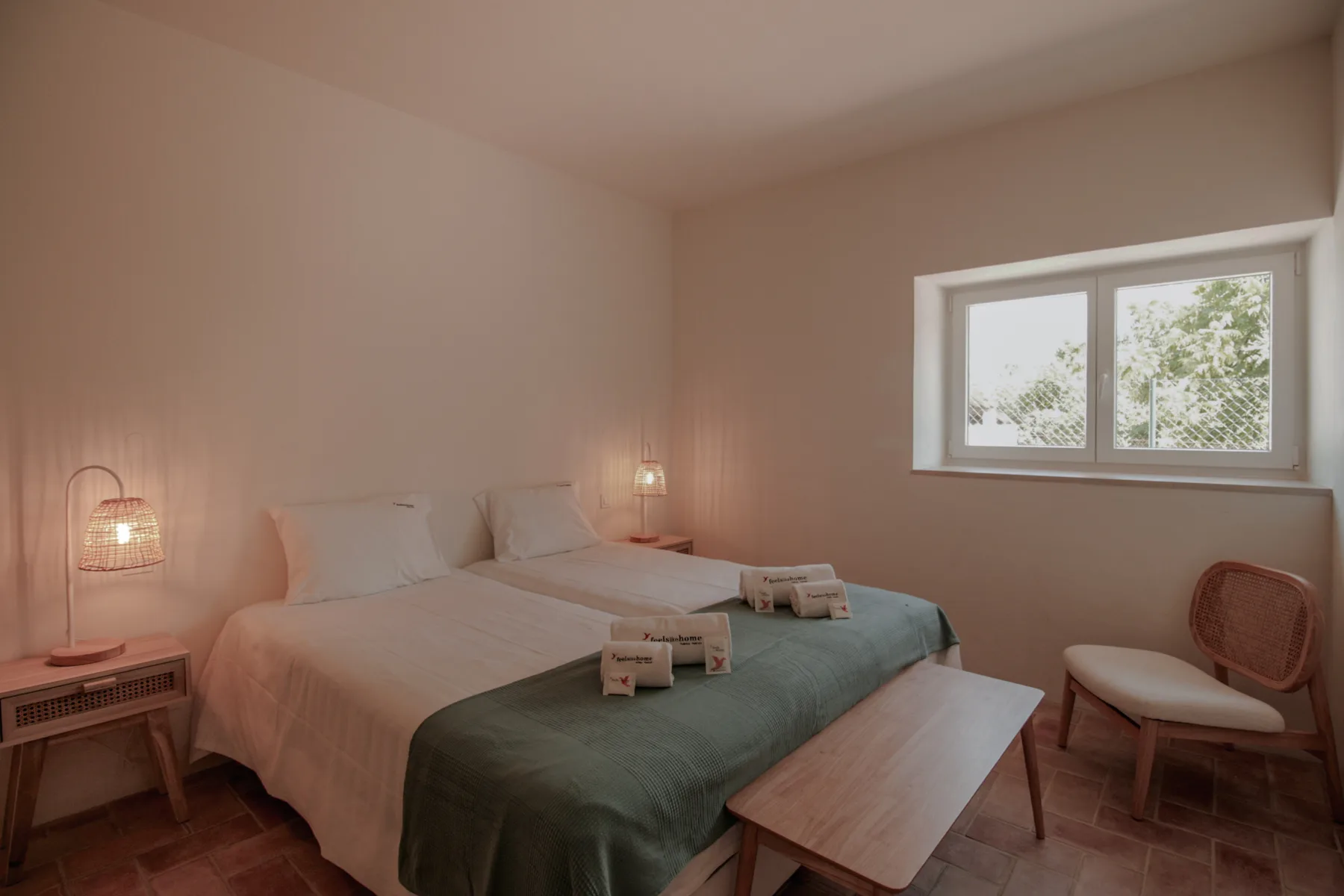 Un dormitorio con una cama, lámparas de noche y una ventana.