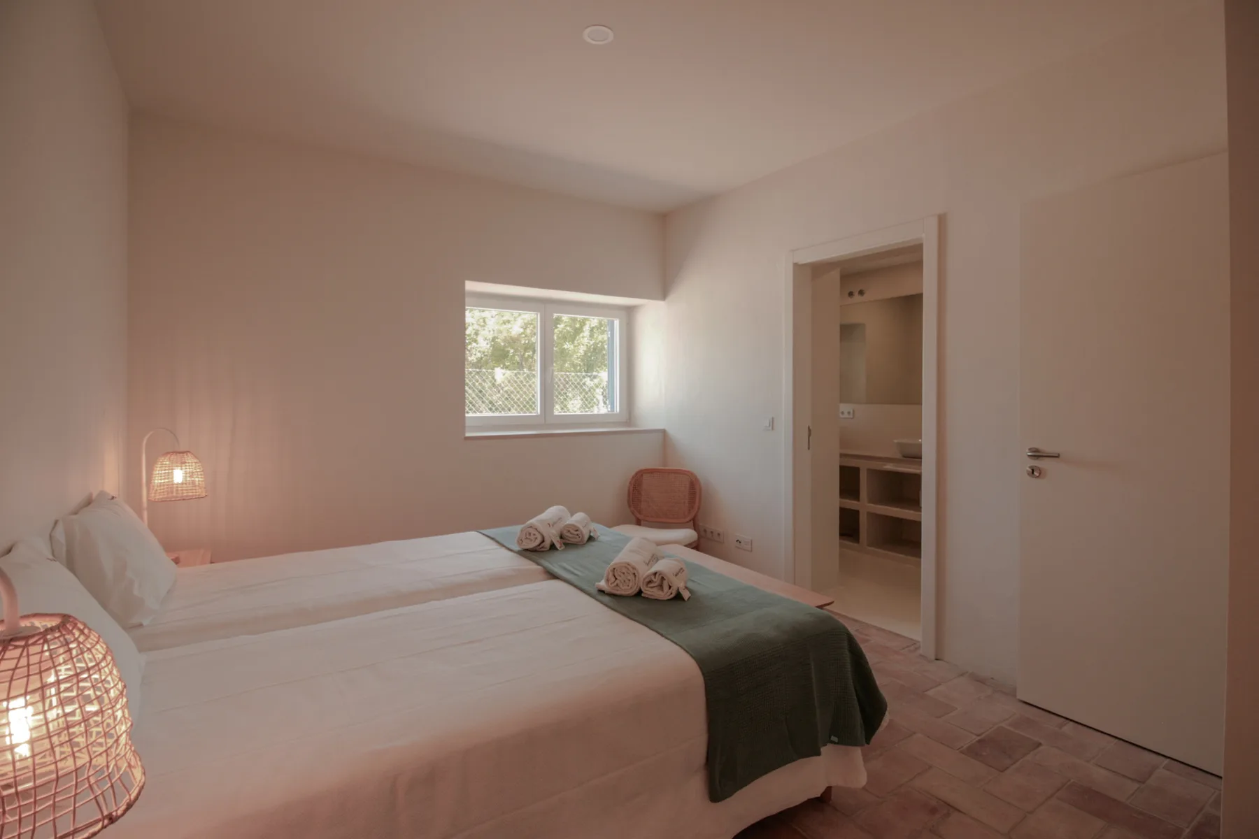 Un dormitorio con una cama grande, una colcha verde y una ventana.