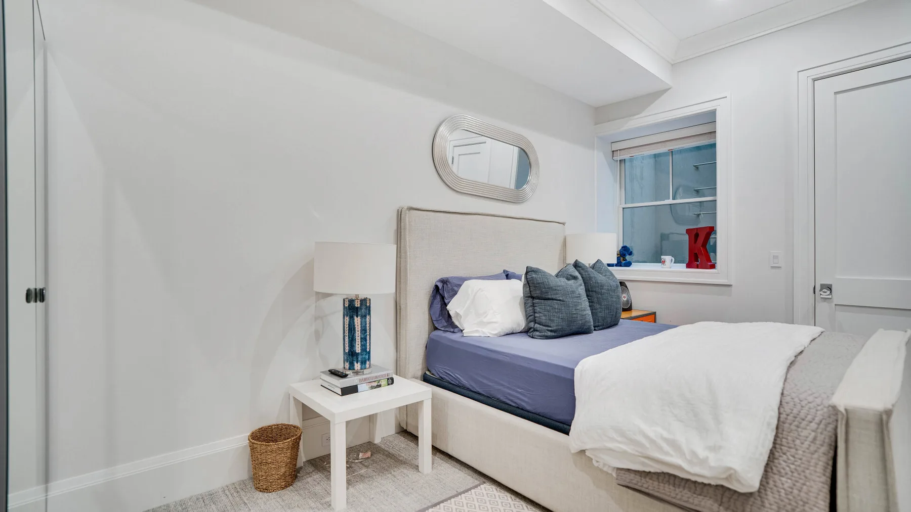 Un dormitorio con una cama, una mesita de noche y una ventana.