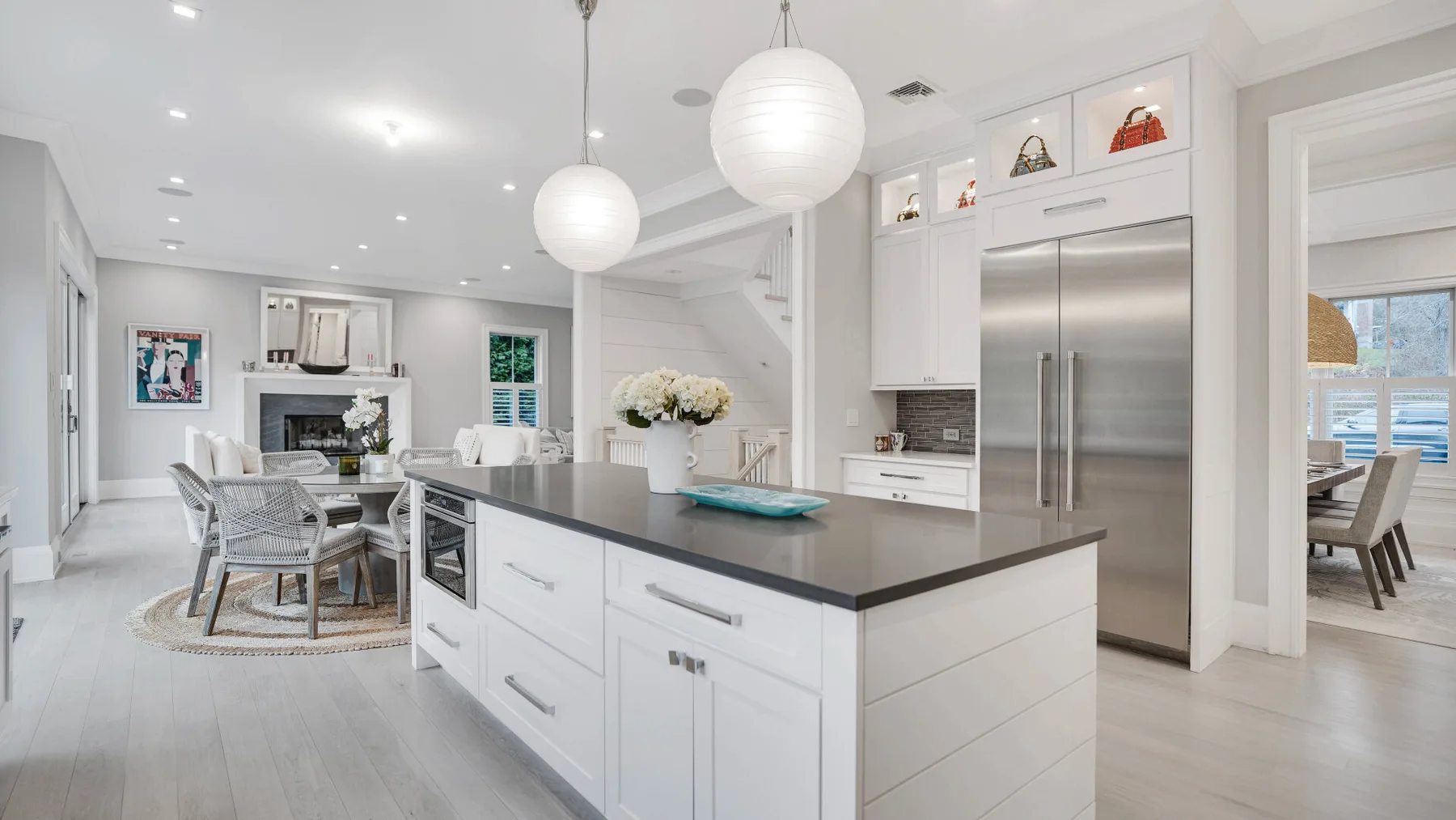 Una cocina luminosa de planta abierta con una isla central y comedor.