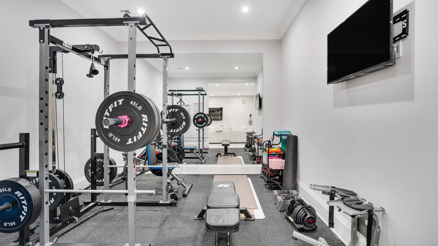 Un gimnasio en casa con equipo de pesas y un banco.