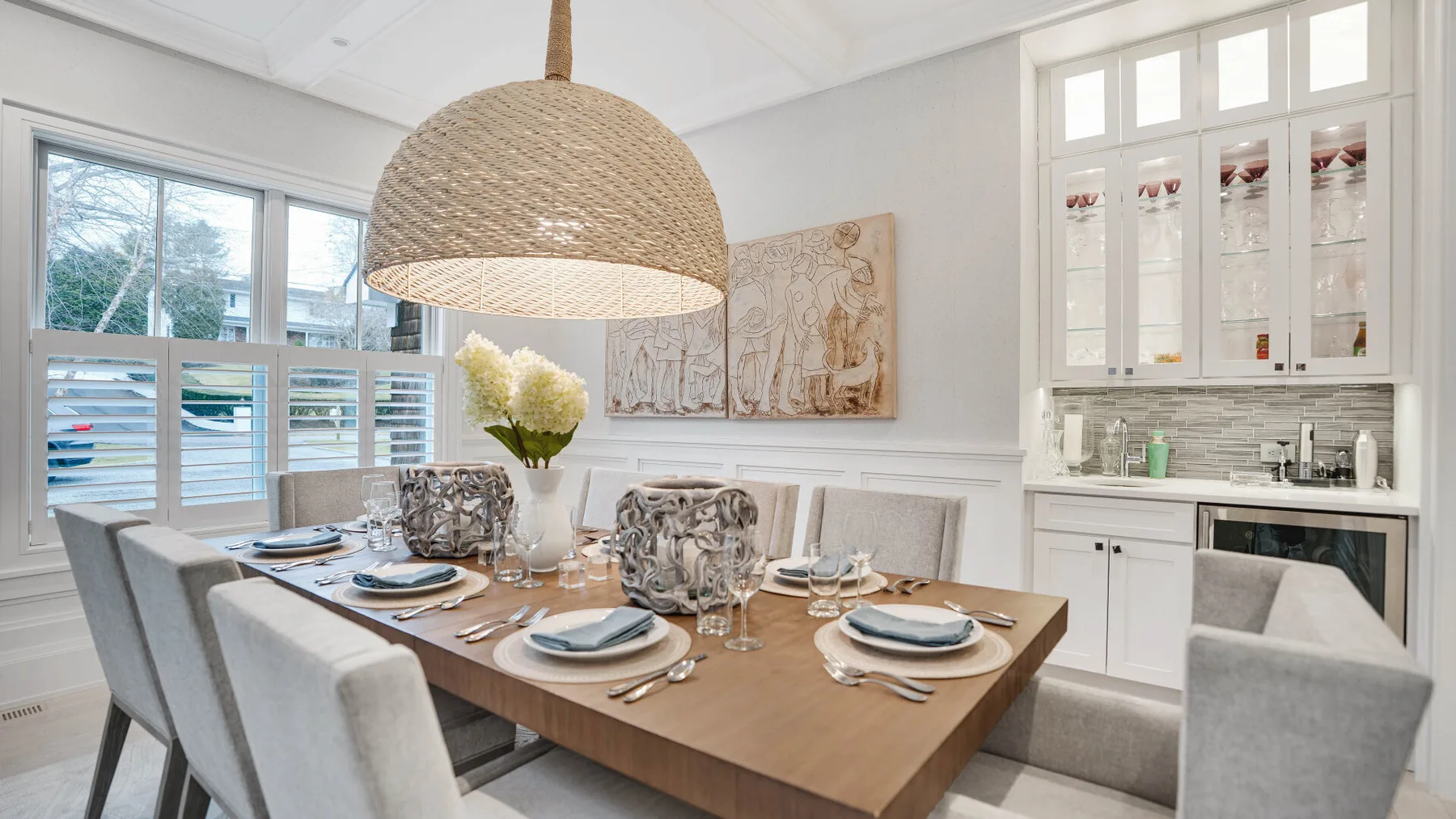 Un comedor luminoso con la mesa puesta junto a una cocina compacta.