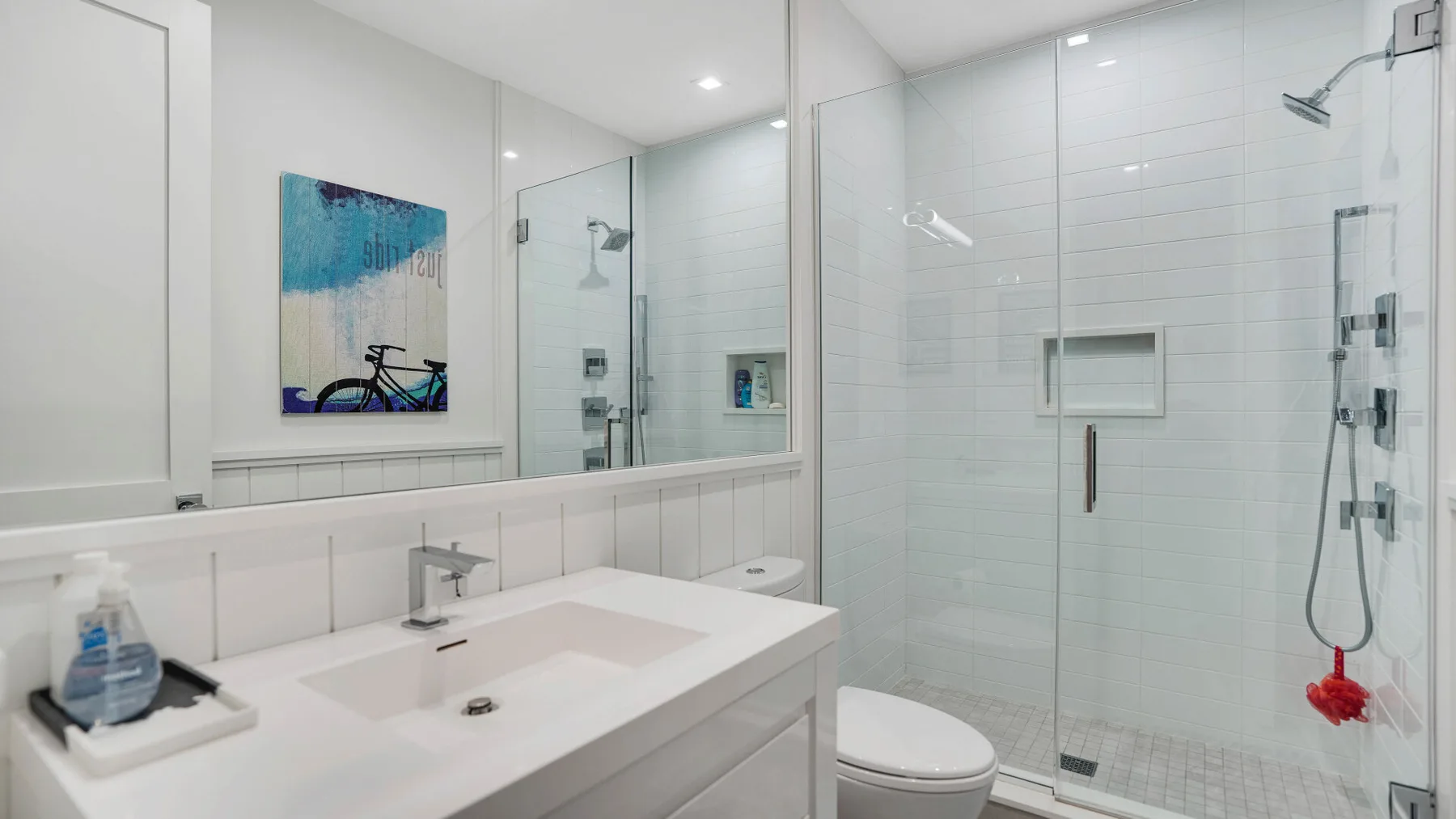 Un baño luminoso con un lavabo amplio y una ducha de vidrio.