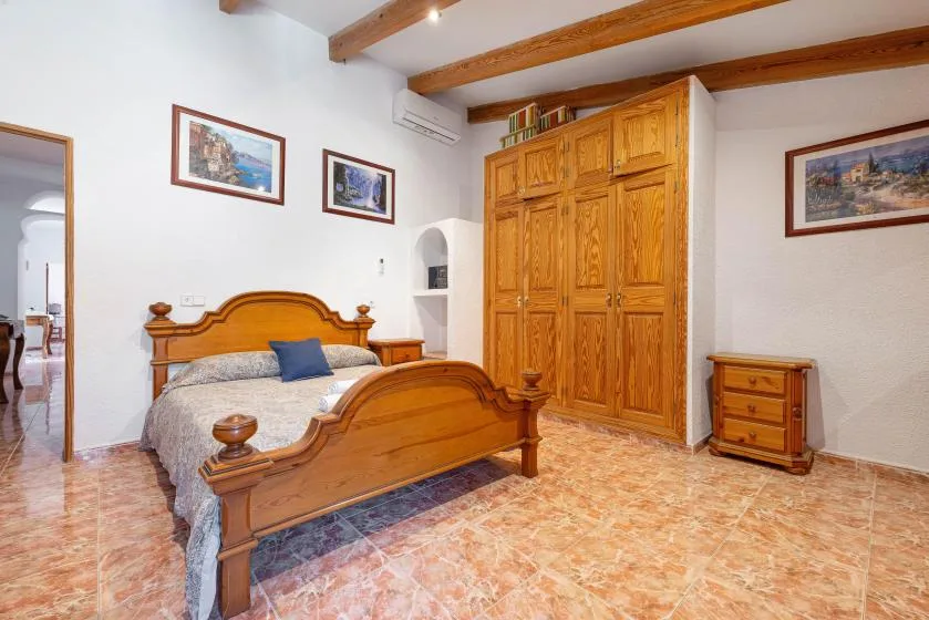 A bedroom with a wooden bed and a large built-in wardrobe.