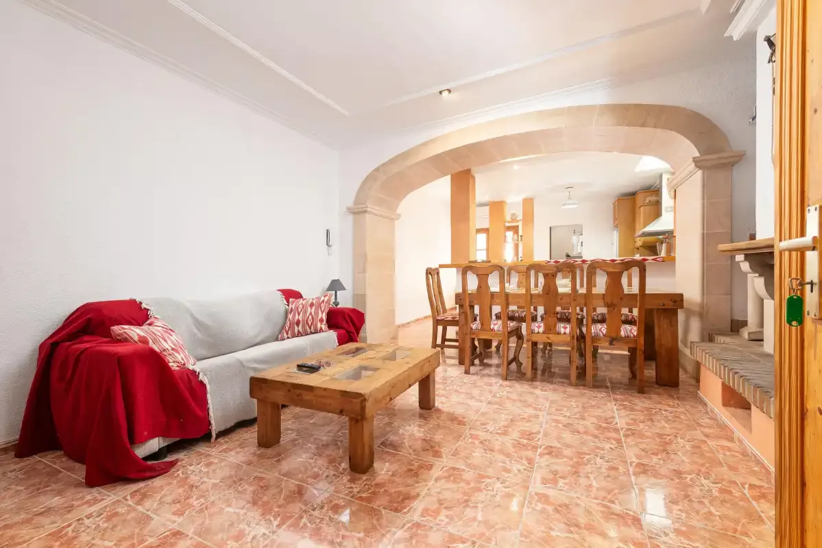 A living and dining room with seating and a wooden dining table.