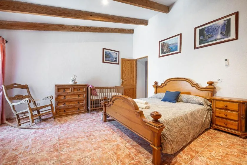 A bedroom with a wooden bed, dresser, and framed pictures on the walls.